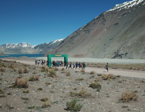 Man running and passing finish line by mountains