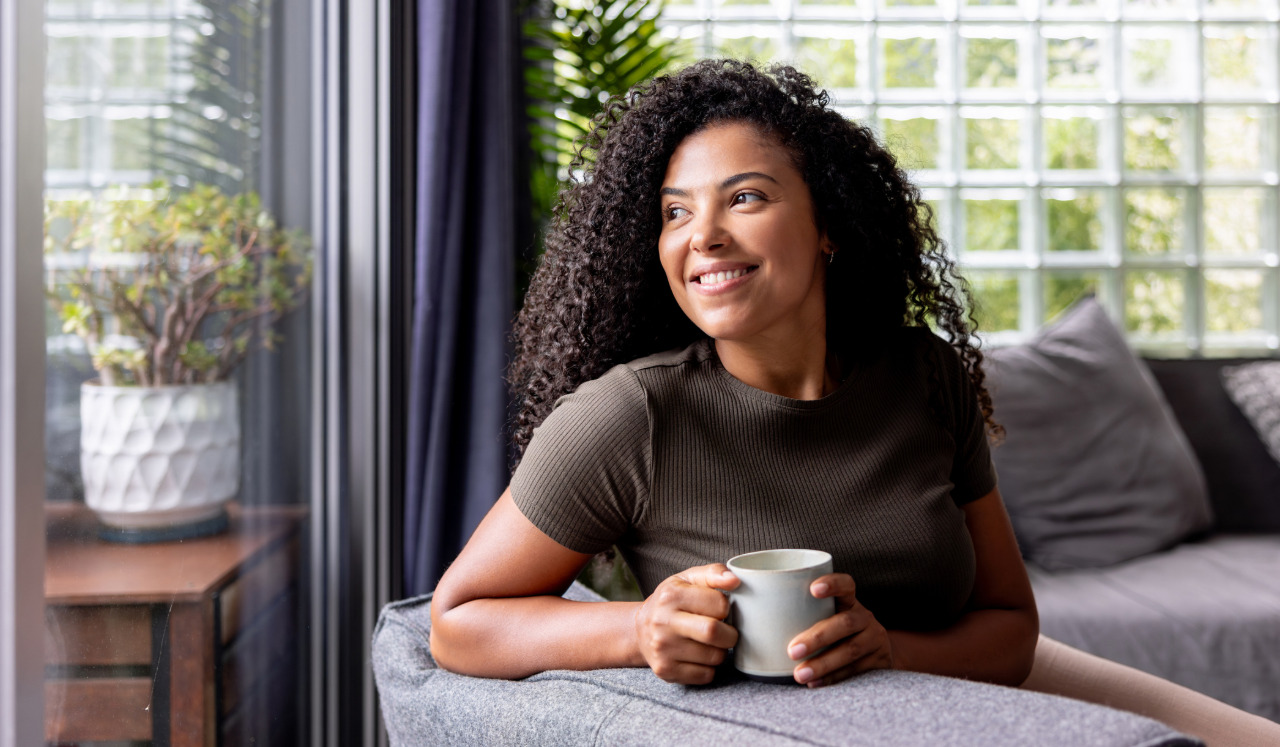 Woman looking out window with coffee