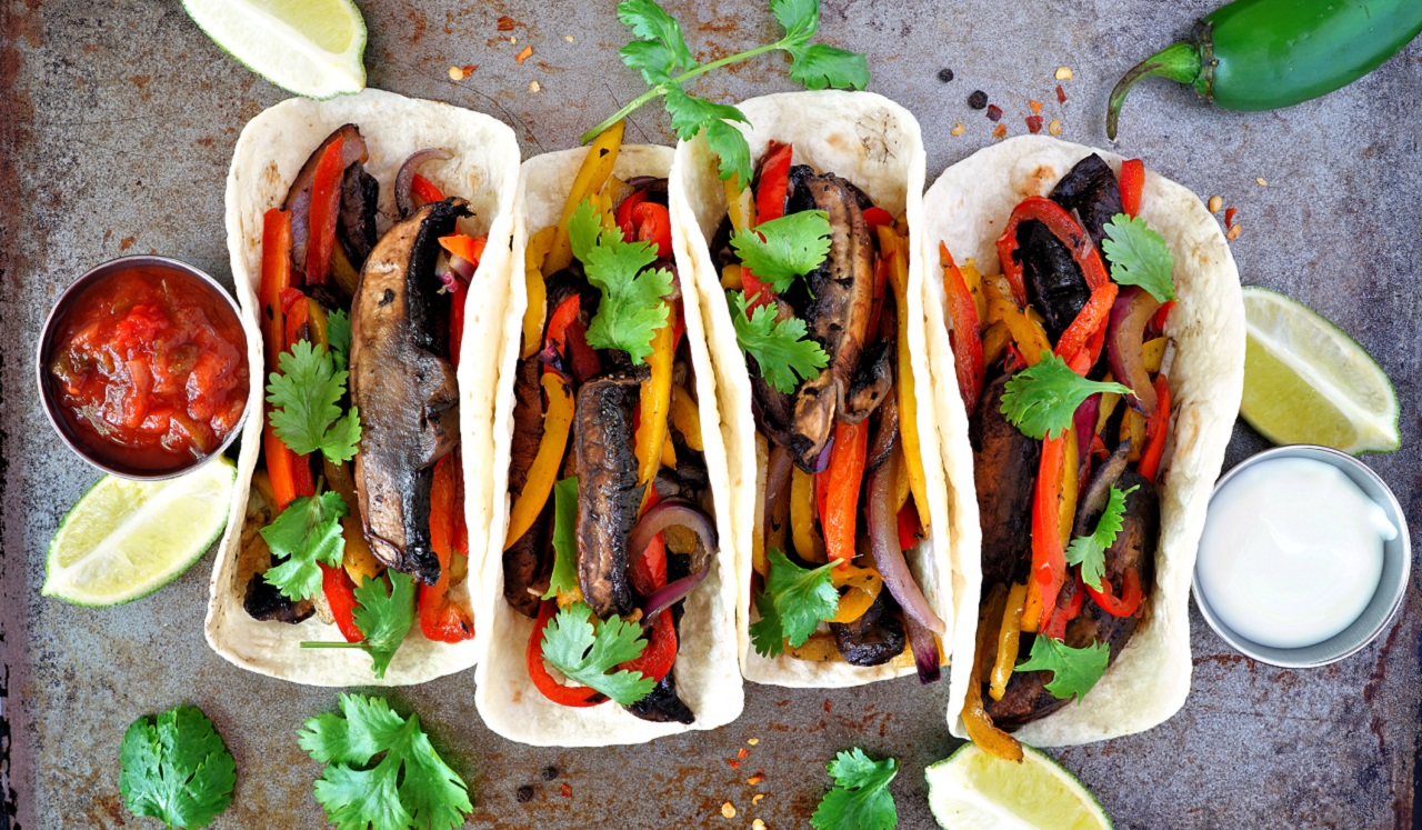 Four tacos stuffed with bell peppers and Portobello mushrooms.