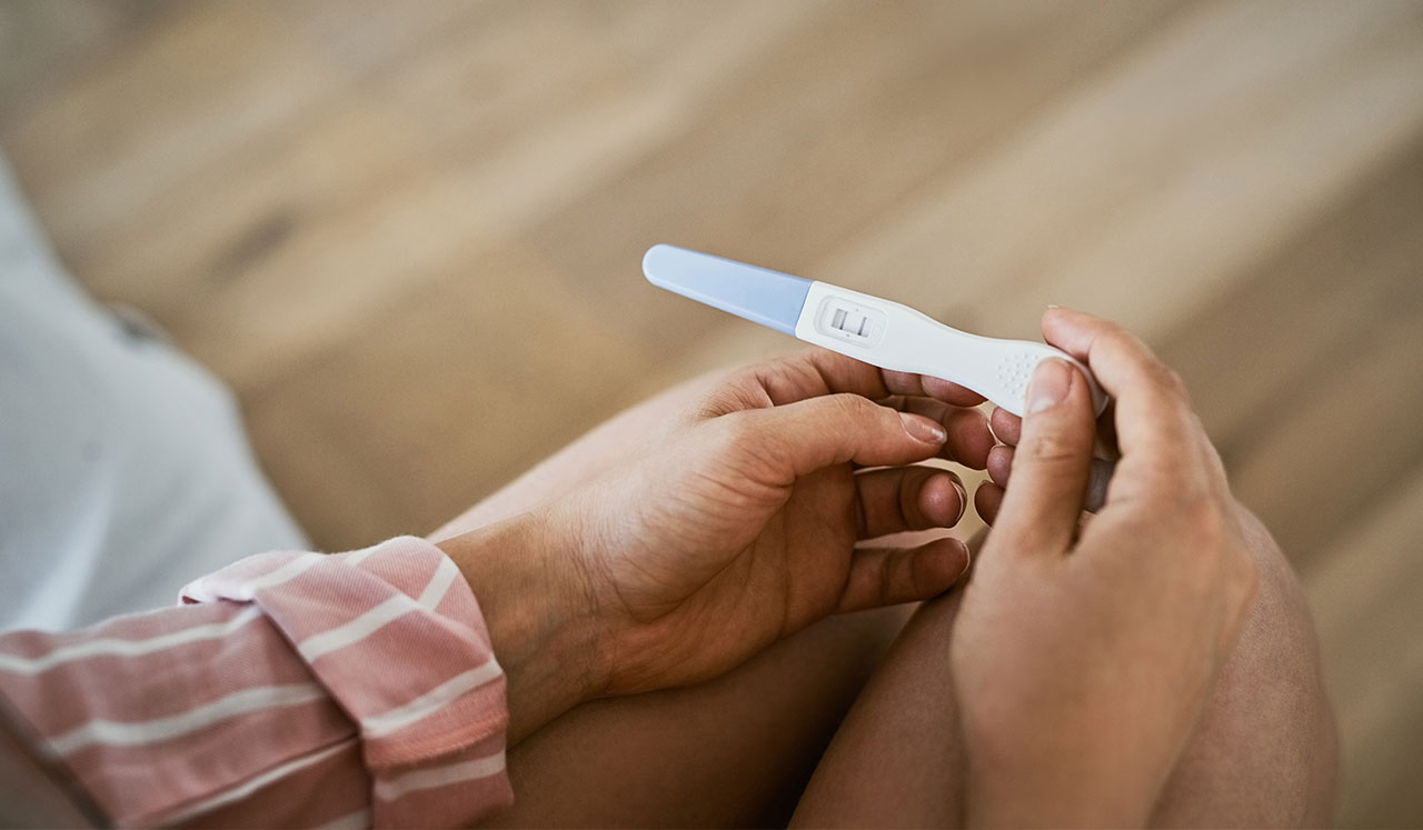 Hands holding a pregnancy test.