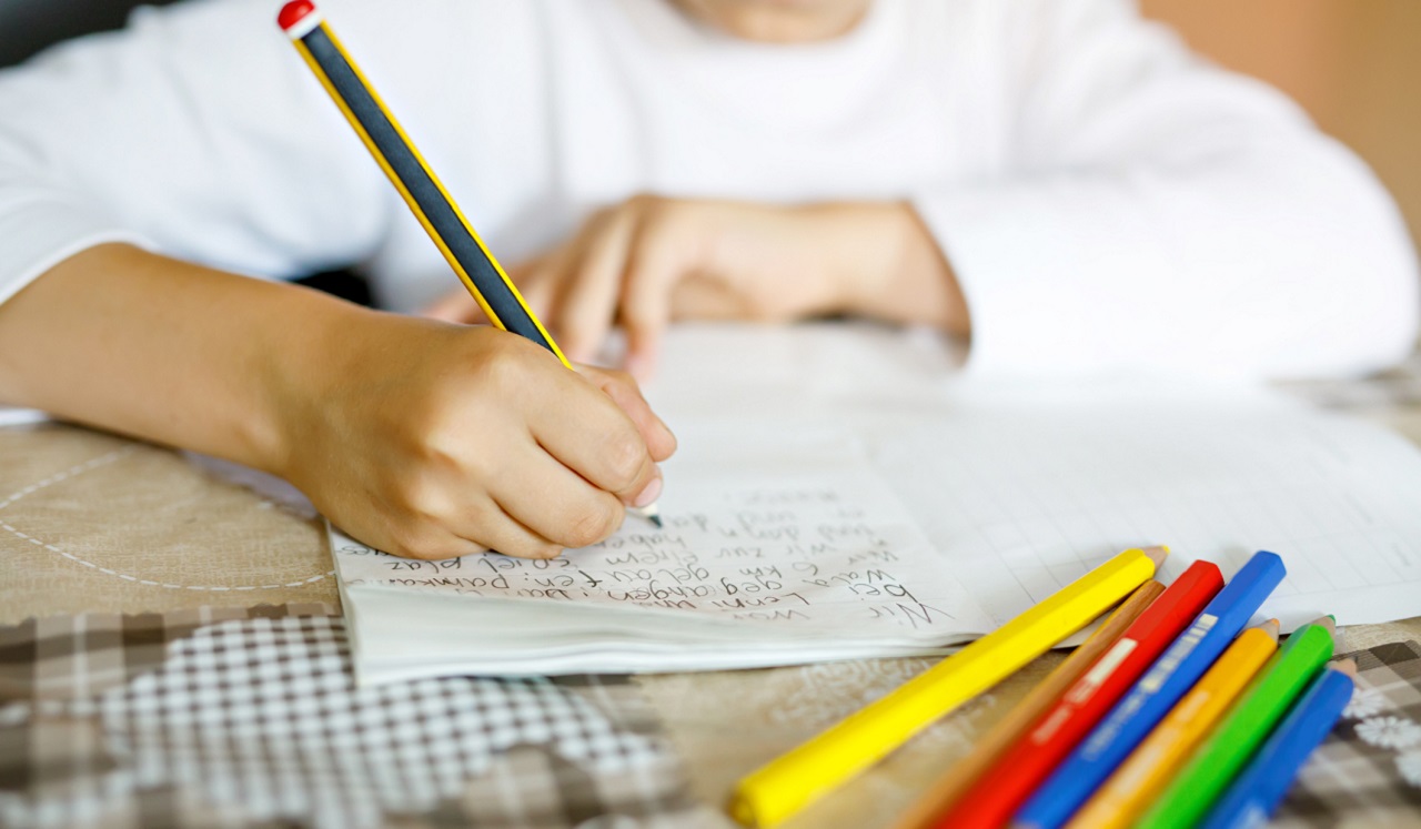 A child writing with a pencil.