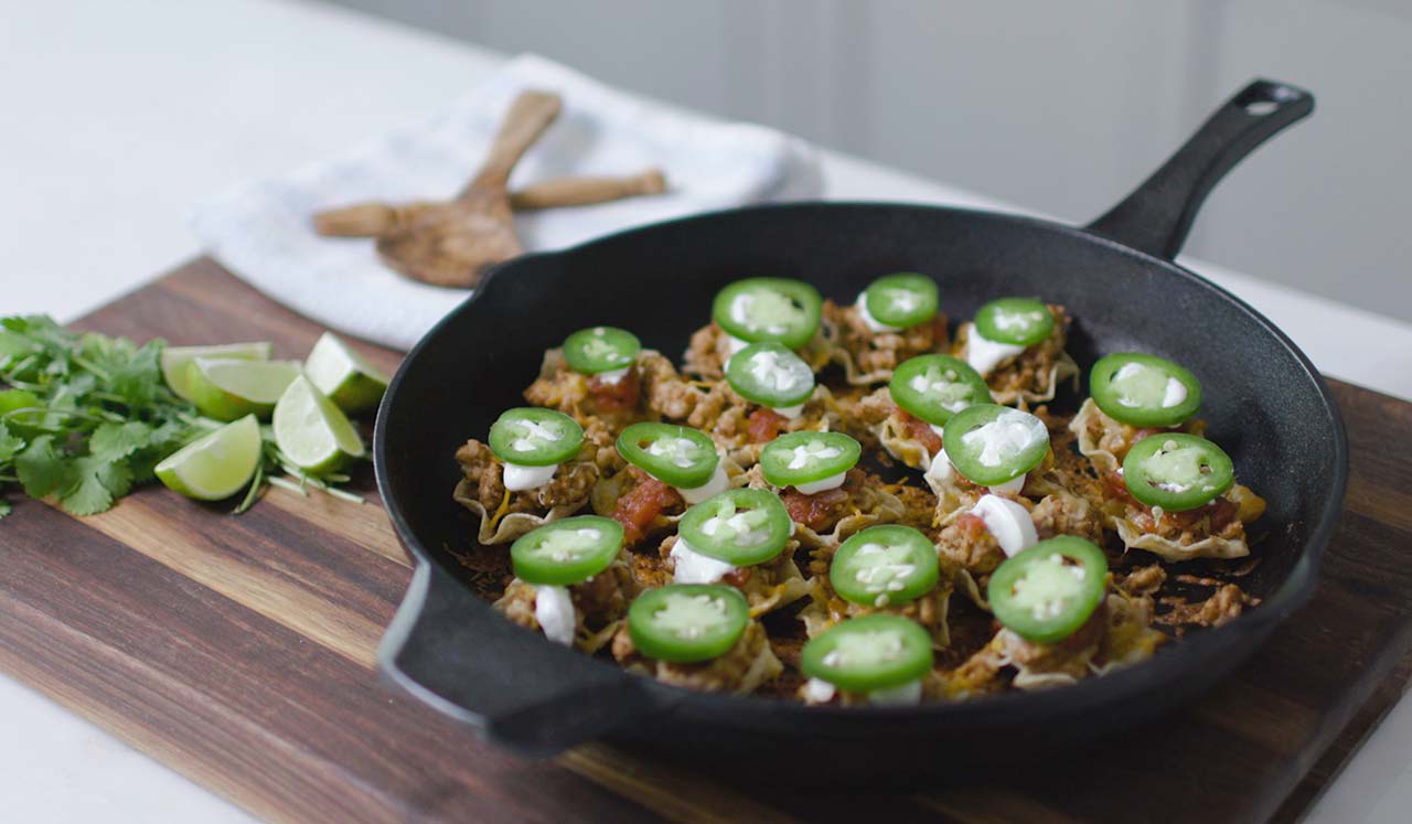 Skillet nachos topped with jalapenos and cheese.
