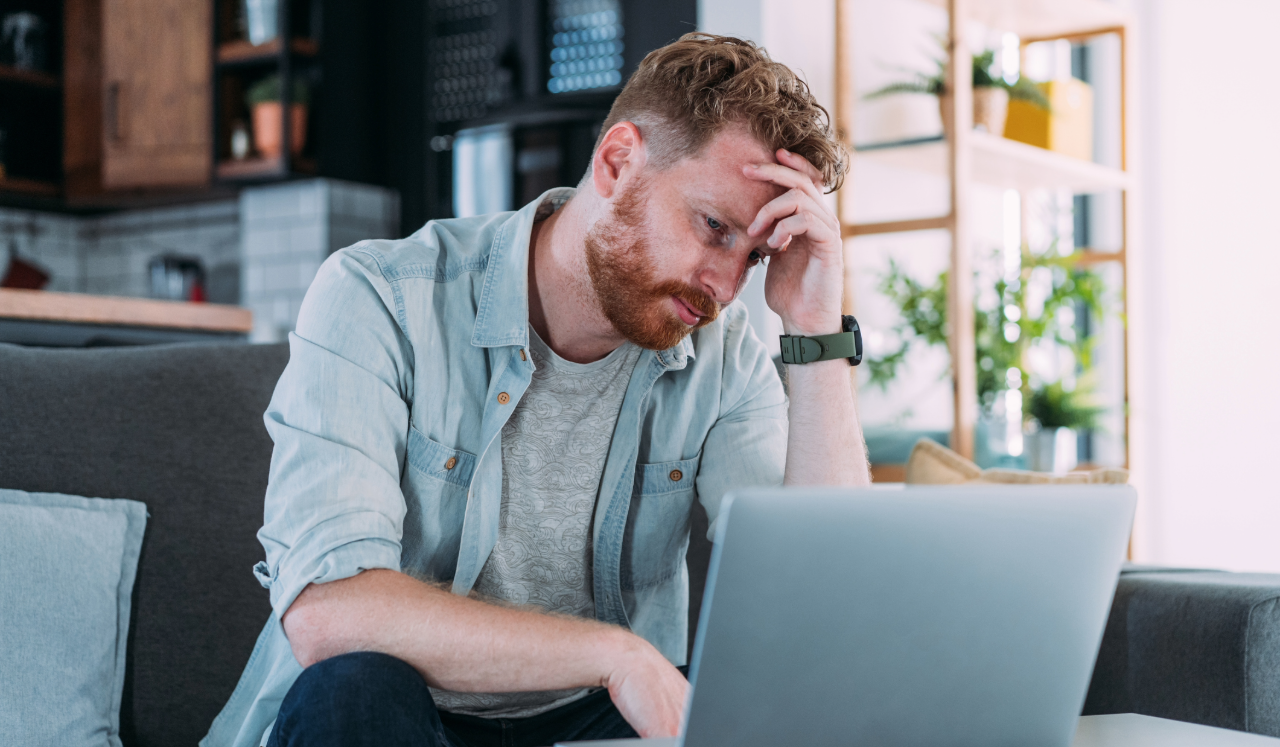 Man stressed looking at computer screen