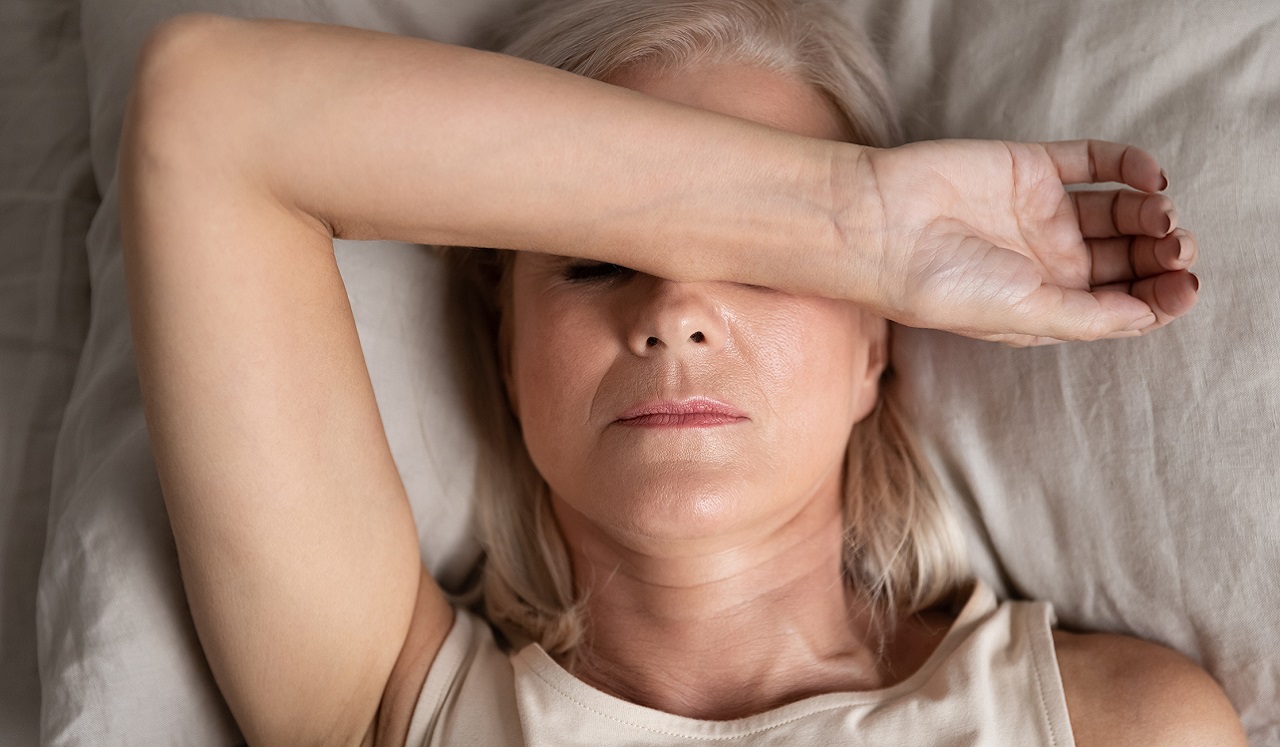 Woman laying down with arm across her head