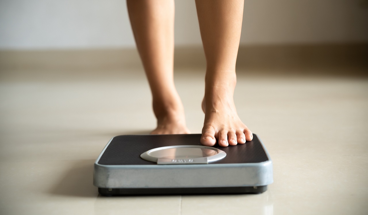 A person's feet stepping on to a scale.