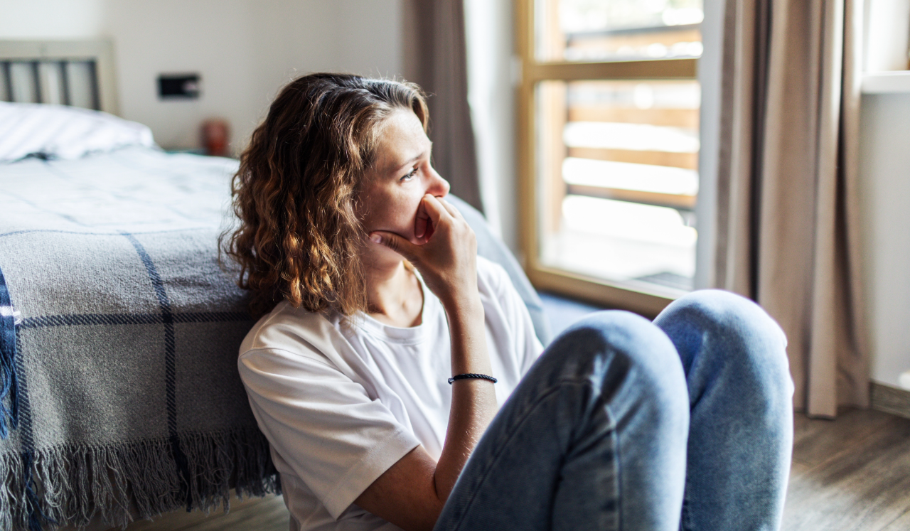 Woman sitting on the floor, stressed out.