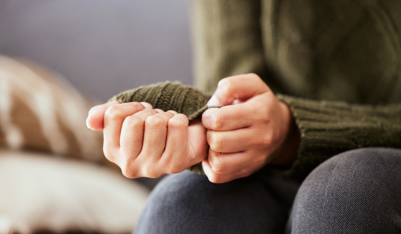 Person worried and anxious, pulling at their sweater