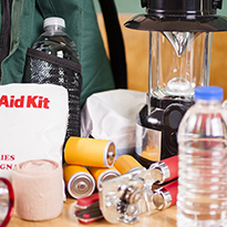 First aid kit, bottled water, a flash light and other items for an emergency kit.