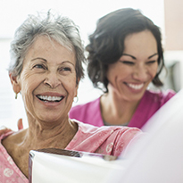 Two women smiling at each other.