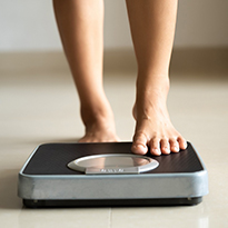 A person's feet stepping on to a scale.