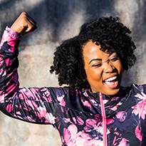 A woman in active wear flexing her biceps.