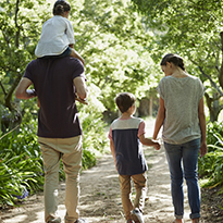 A family of four walking along a trail.