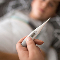A digital thermometer with child in background