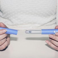 Person holding injectable weight loss drug