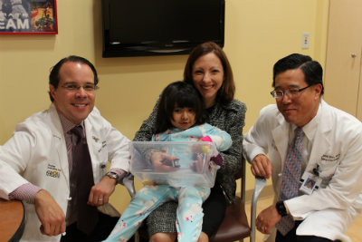 Pediatric patient poses with physicians