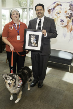 Therapy dog  named Gracie with two people