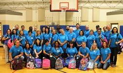 Group photo of employees donating backpacks