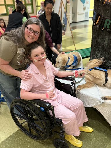 TIRR Memorial Hermann former patient, Eleanor, visits with therapy dogs. 