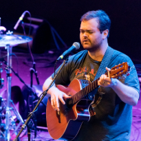 TIRR Memorial Hermann patient, Brandon Ray, plays his guitar and sings after recovery.