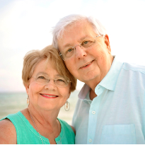 TIRR Memorial Hermann patient, Gary Thompson, stands on the beach with his wife.