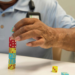 TIRR Memorial Hermann patient, Hector Alvarez, carefully stacks dice as part of therapy.