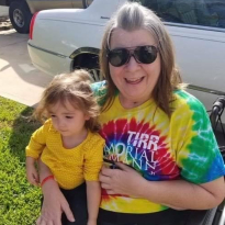 Susan Slovak, a TIRR Memorial Hermann patient, smiles while holding a child in her arms.