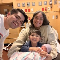 family smiling in hospital bed