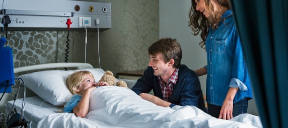 patient in hospital bed with parents