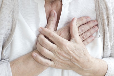 Hands clutch chest to show chest pain