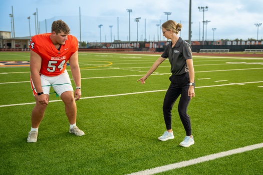 Footballer with trainer on field