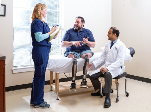 Alex Weatherford, osseointegration patient, meets with Kristin Reeves, PT, and Vinay Vanodia, MD.