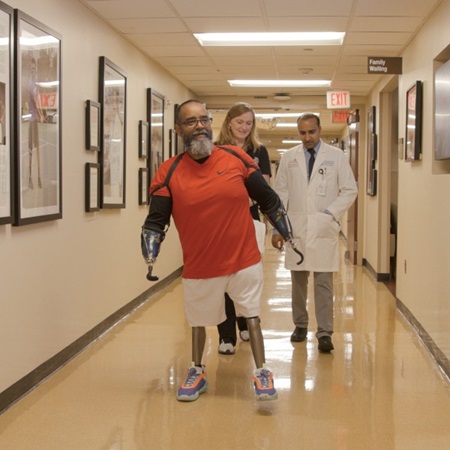 Man with prosthetic limbs walks