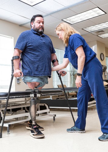 TIRR Memorial Hermann osseointegration patien=t, Alex, stands with minimal assistance.