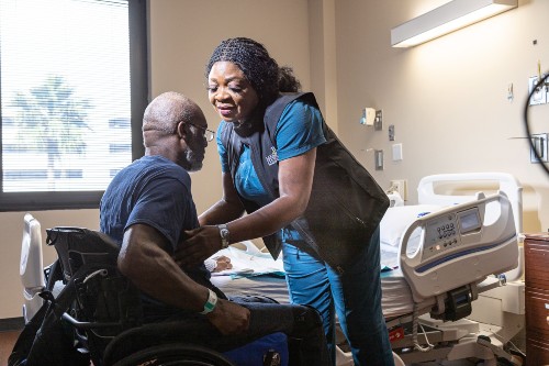 TIRR Memorial Hermann nurse assists patient into wheelchair