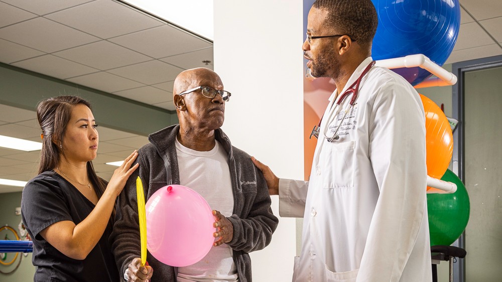 Memorial Hermann Rehabilitation Hospital-Katy patient and therapists work in the physical therapy gym