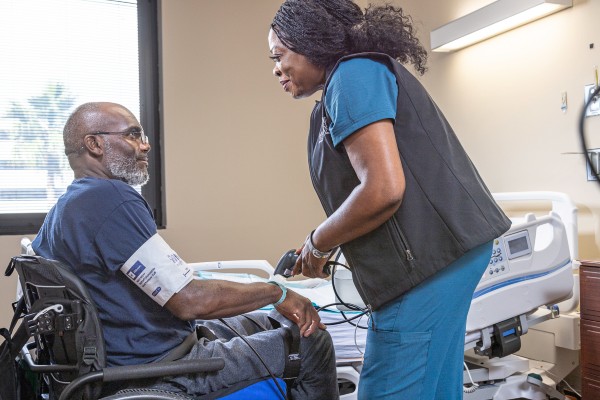TIRR Memorial Hermann patient and care giver talk in the patient care unit.