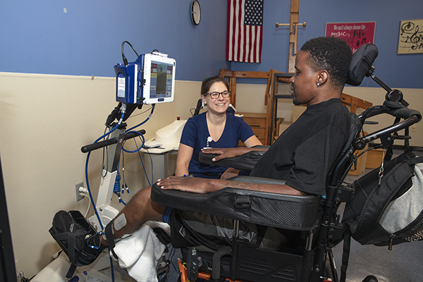 A patient using assistive technology works with therapist.