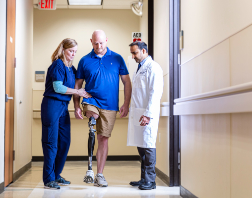 A TIRR Memorial Hermann patient walks with assistance from osseointegration and health care workers.