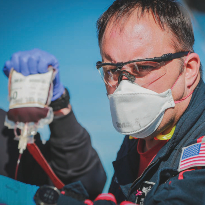 An on-scene Life Flight Paramedic holds a transfusion bag.