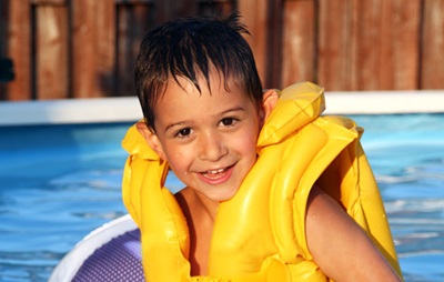 Child wearing a life jacket in a pool