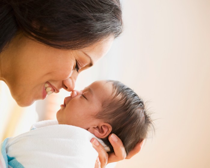 woman smiling and holding baby