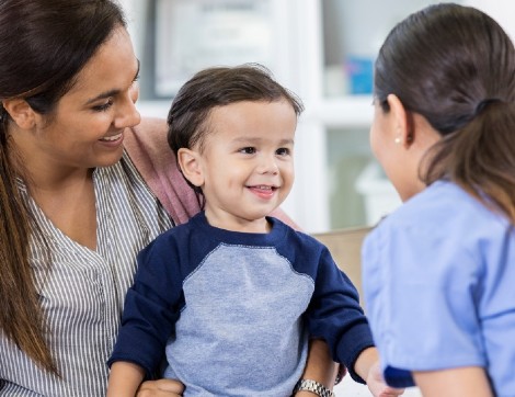 toddler boy smiling with pediatrician