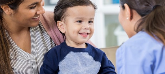 toddler boy smiling with pediatrician