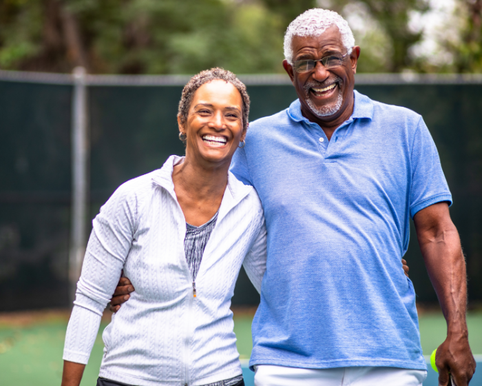 African american couple in tennis outfits smiling
