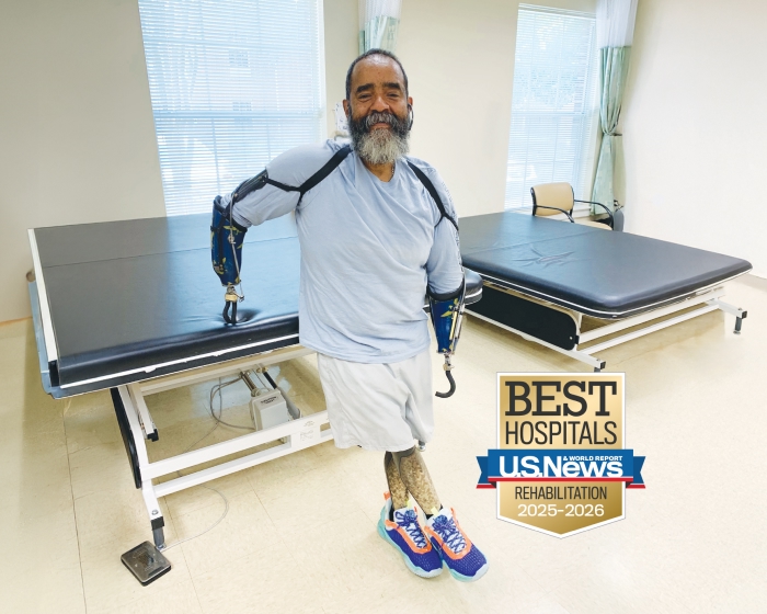 TIRR Memorial Hermann former patient poses with prosthetics 