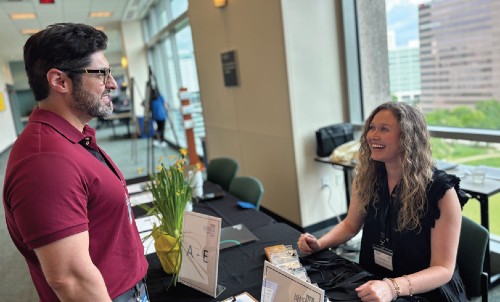 A woman sits at a desk to check-in an up-coming visitor at a TIRR Memorial Hermann conference