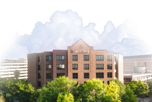 An aerial view of TIRR Memorial Hermann with a watercolor sky in the background.