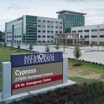 The Memorial Hermann Cypress Hospital campus signage with the hospital in the background.