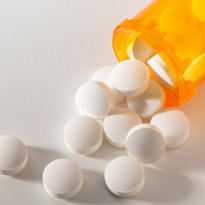 Pills falling out of a bottle