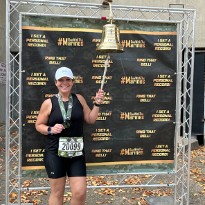 Katie Payne, NewStart success story, rings the bell following her marathon finish.